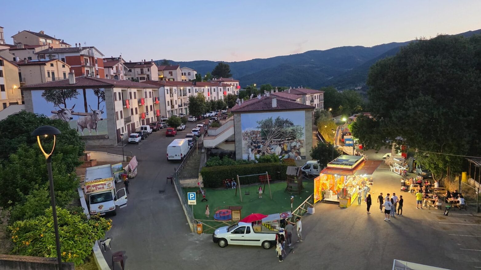 La piazza di Accettura la sera, con i murales dedicati al Maggio.